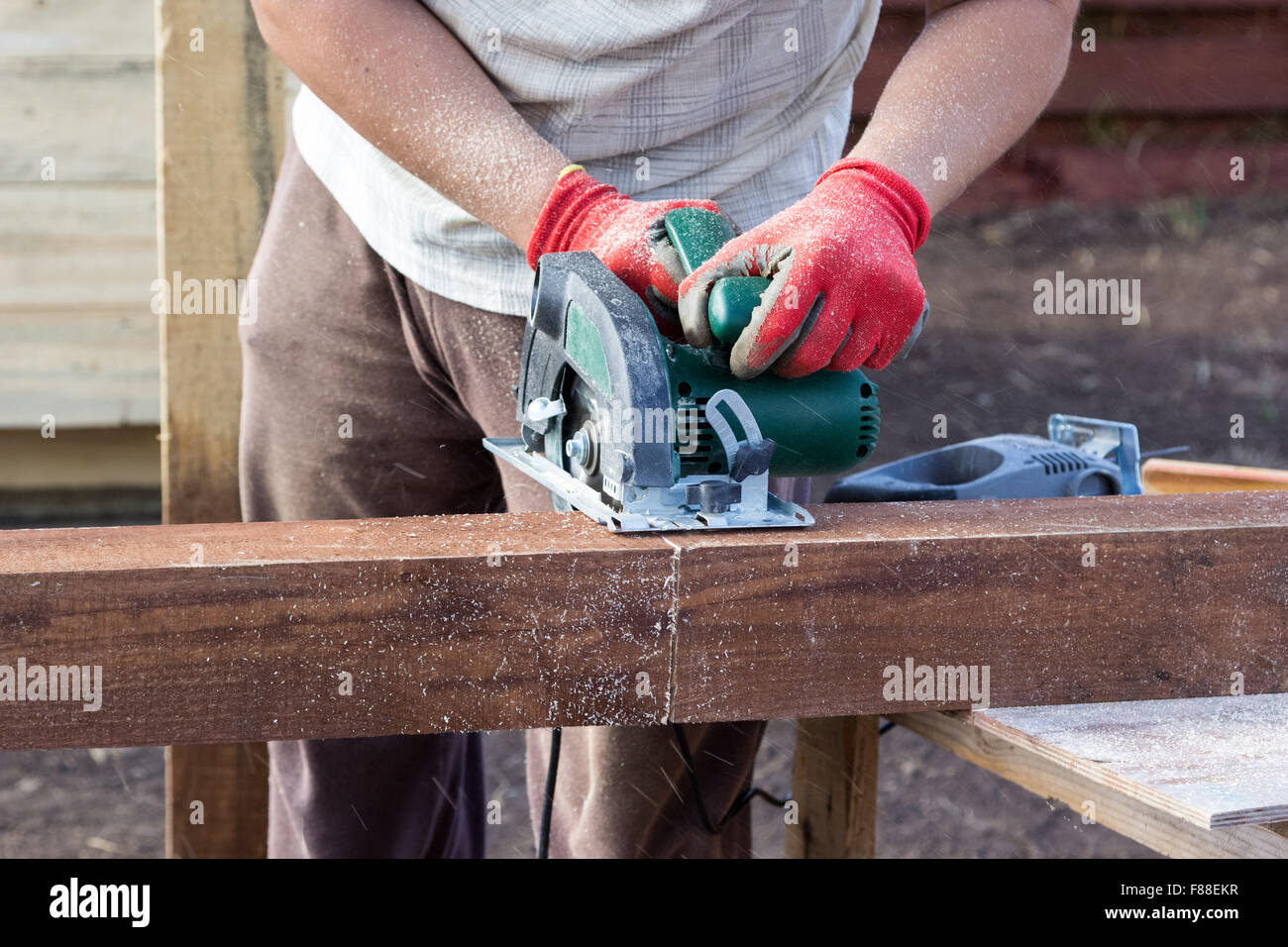 Couper les mains de l'homme traverse en bois avec scie circulaire Photo  Stock - Alamy