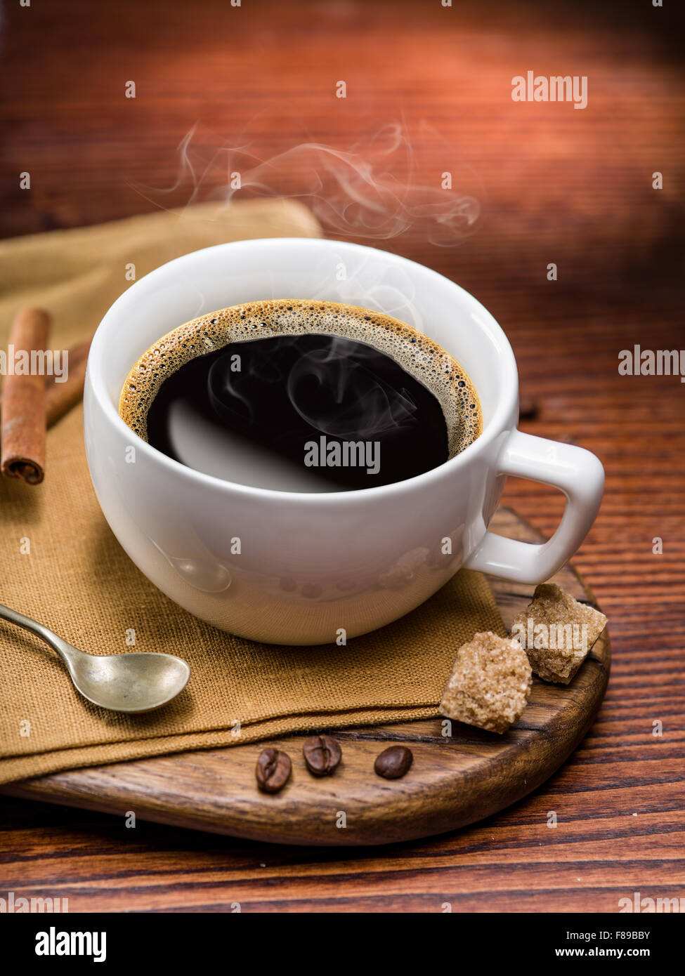 Tasse de café et sucre de canne glaçons sur table en bois. Banque D'Images