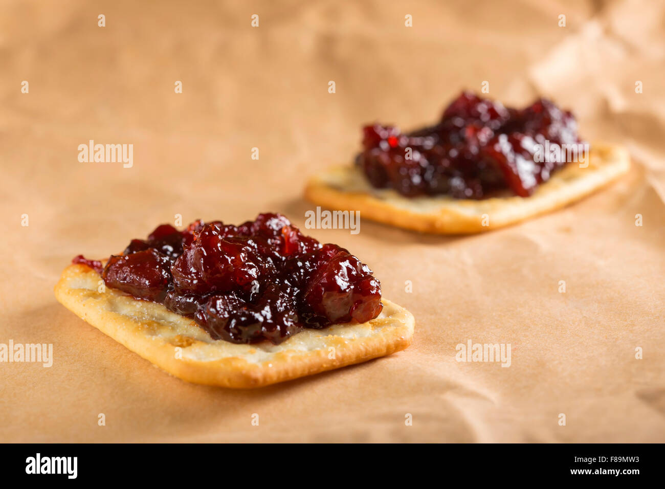 Confiture de coings sur saltine crackers sur papier Banque D'Images