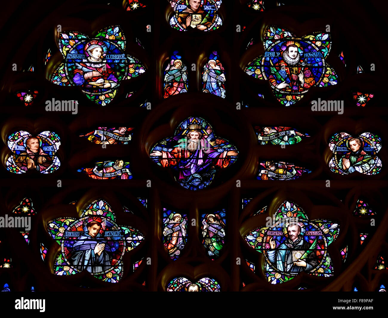 Londres, Angleterre, Royaume-Uni. Eglise catholique romaine de l'English Martyrs, Tower Hill. Vitrail : le Christ crucifié entouré Banque D'Images