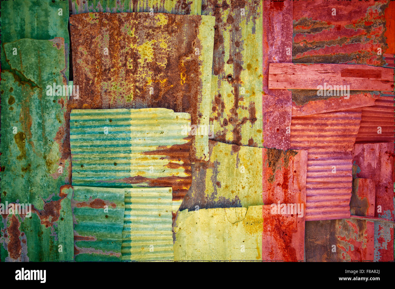 Un résumé de l'image d'arrière-plan le drapeau du Mali peint sur tôles ondulées rouillées de chevauchement pour former un mur ou une clôture. Banque D'Images