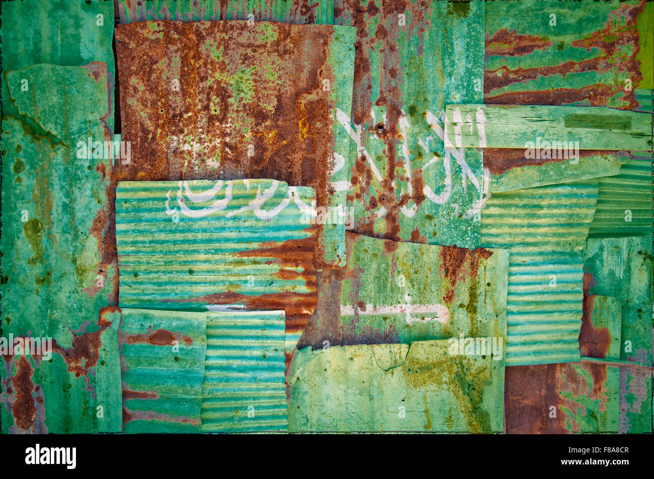 Un résumé de l'image d'arrière-plan le drapeau de l'Arabie saoudite peint sur de tôles ondulées rouillées pour former un mur qui se chevauchent Banque D'Images