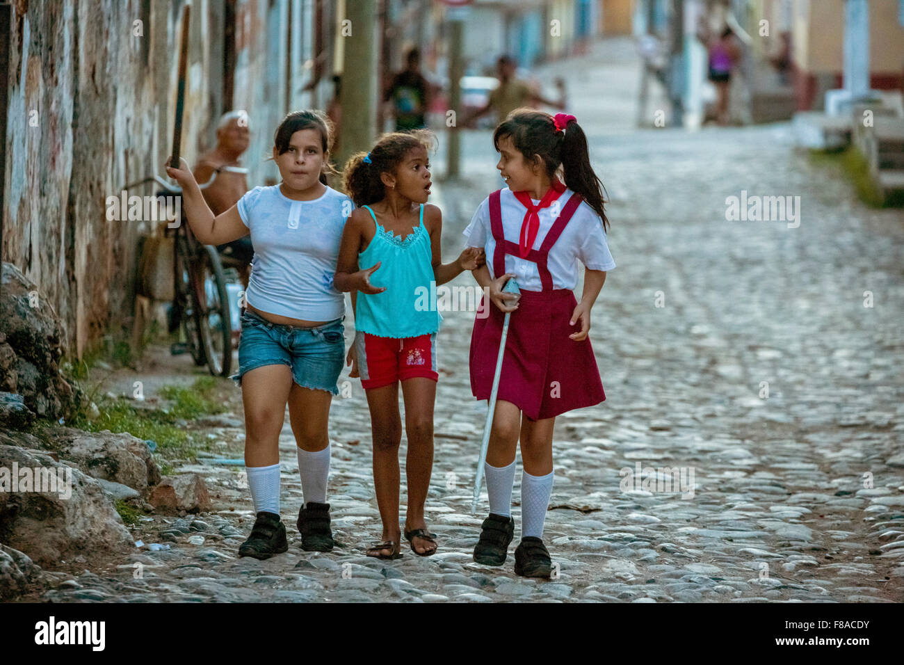 Trois filles de discuter sur la route, à l'école des filles, enfants, scène de rue dans la vieille ville de Trinidad, Trinidad, Cuba, Sancti Spírit Banque D'Images