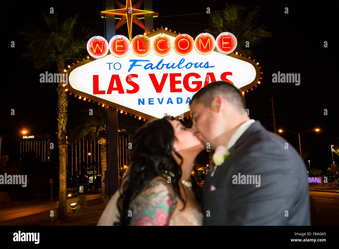 Bride and Groom kissing en face de la bienvenue à Las Vegas Nevada signer la nuit. Banque D'Images