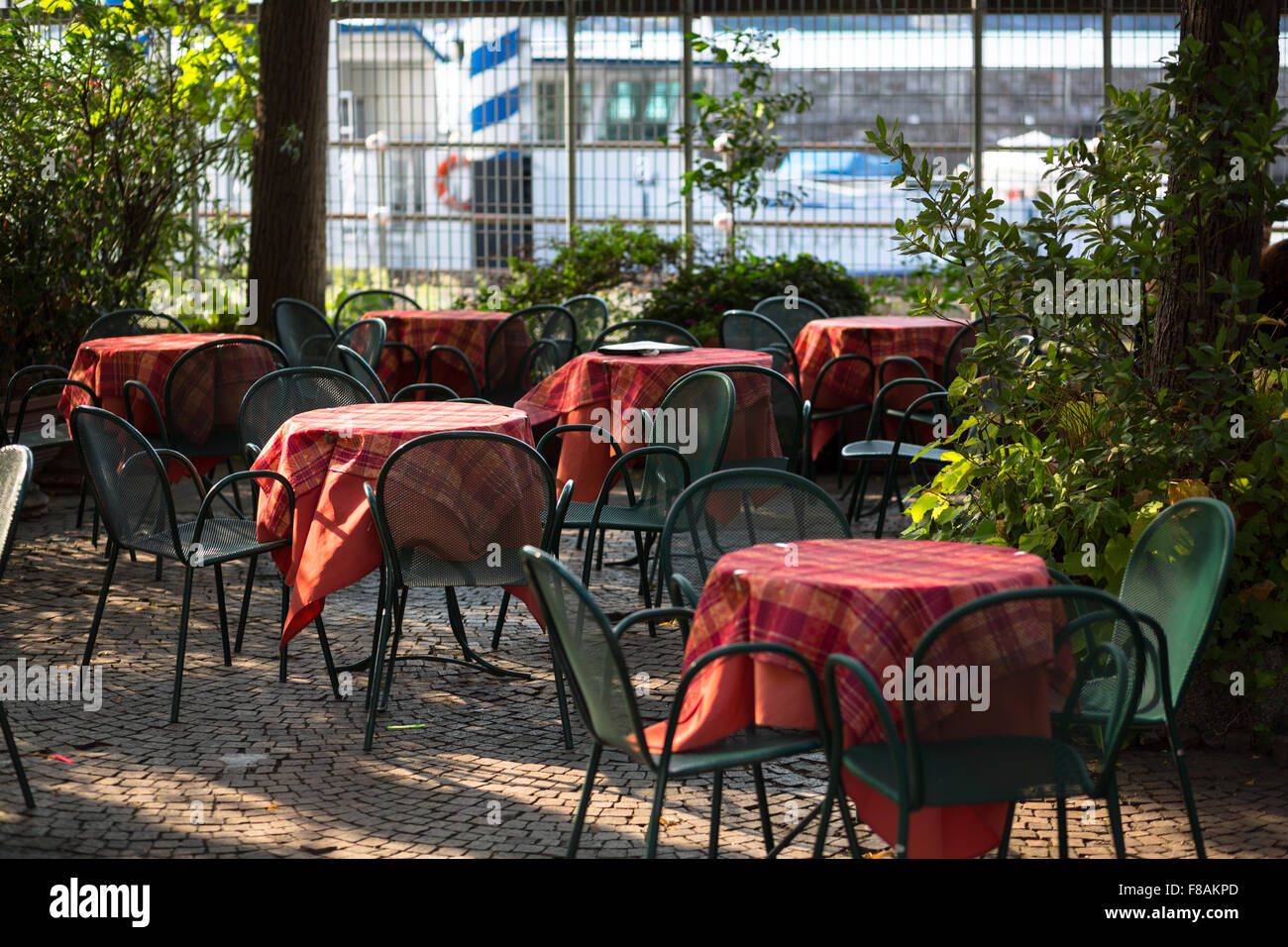 Petit coin café en plein air avec chaises et nappes rouge - Côme, Italie Banque D'Images