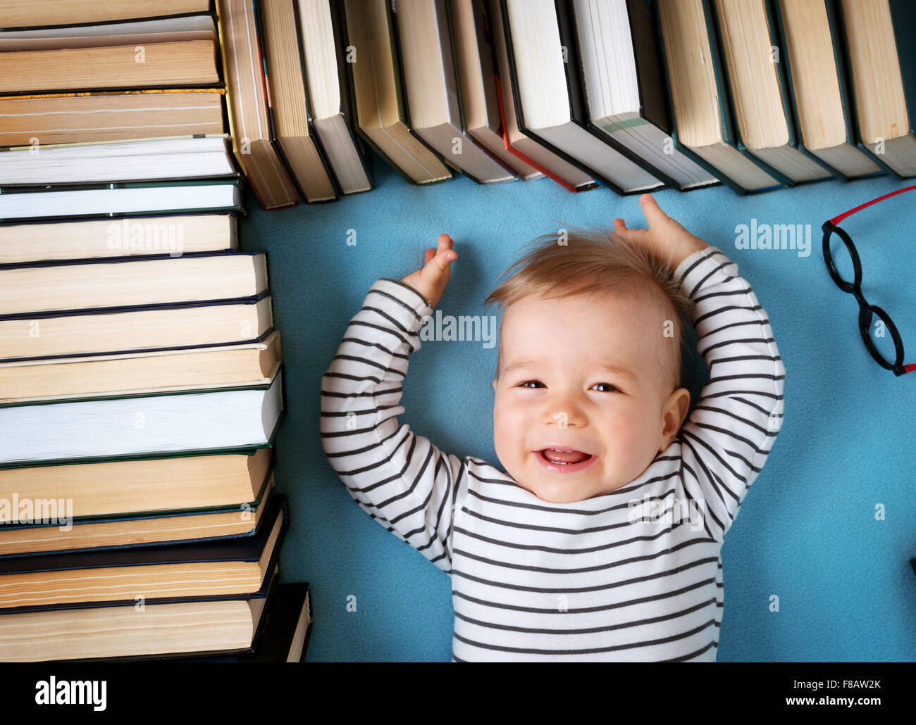 Un an bébé avec spectackles et livres Banque D'Images