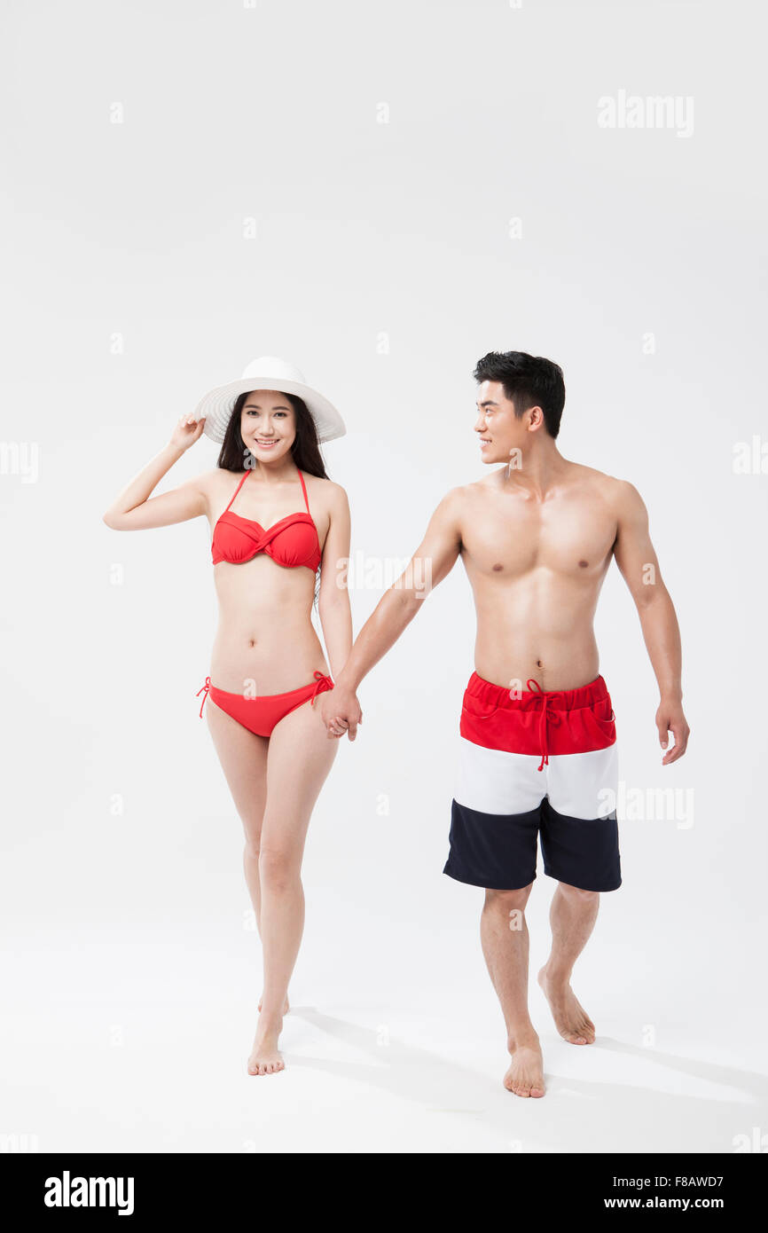 Couple in swimsuits marche main dans la main Banque D'Images