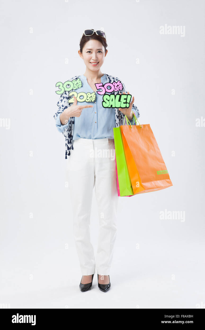 Woman holding shopping bags avec des messages de vente Banque D'Images