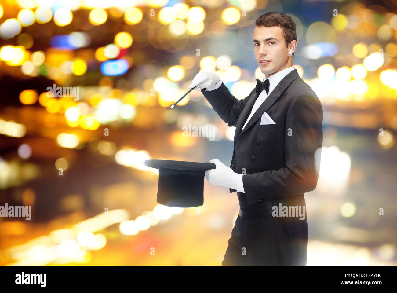 Magicien dans top hat avec Magic wand montrant trick Banque D'Images