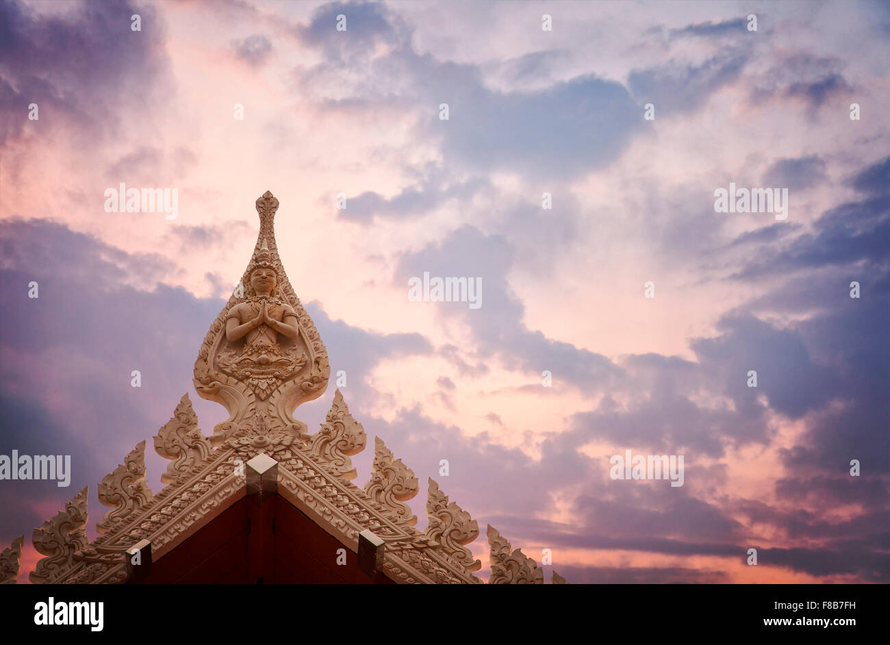 Détail de la toiture d'un temple bouddhiste avec ciel coucher de soleil spectaculaire. La Thaïlande. Banque D'Images