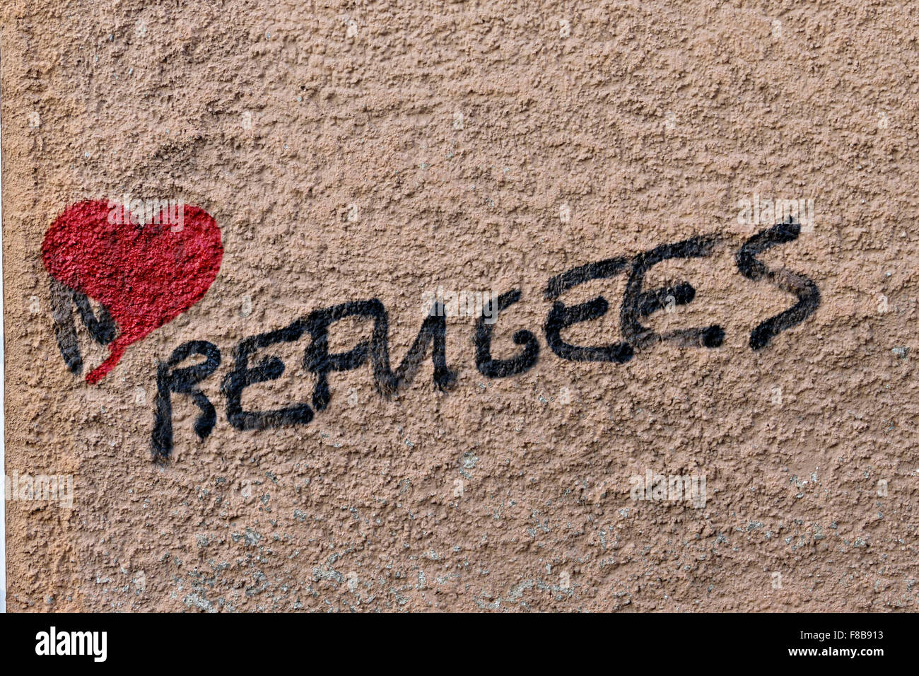 Les réfugiés avec amour rouge coeur graffiti sur mur rose Banque D'Images