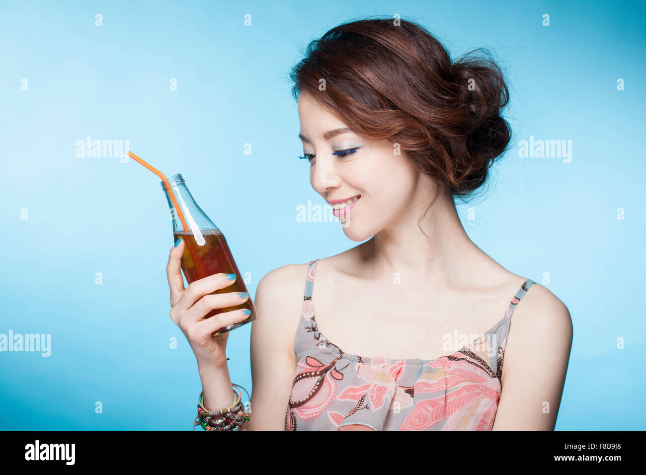 En été porter femme tenant un verre bouteille de verre avec de la paille et à la bas Banque D'Images