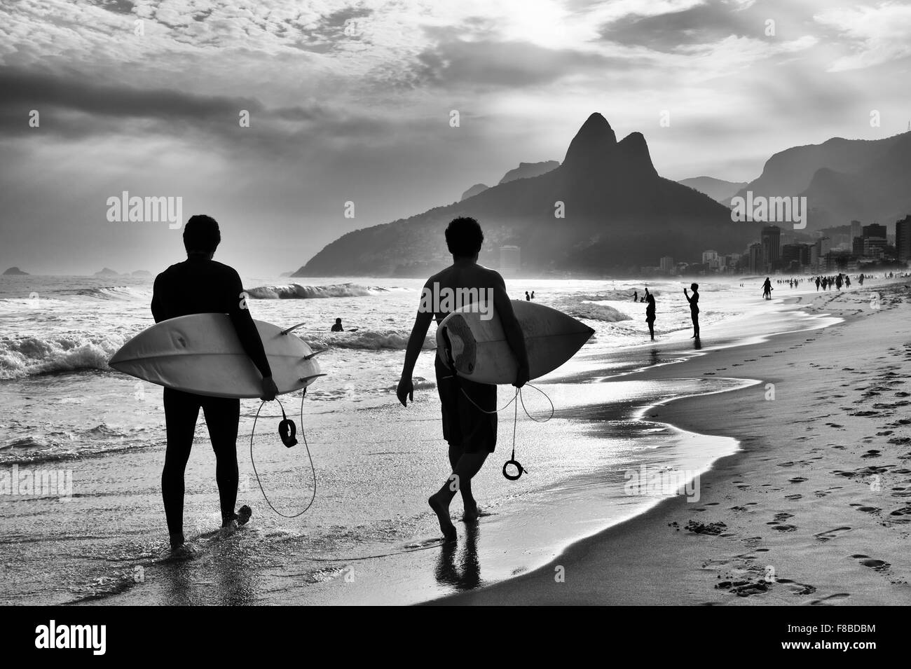 Noir et blanc panoramique vue de Rio de Janeiro, Brésil avec surfers brésiliens de marcher le long du rivage de la plage d'Ipanema Banque D'Images