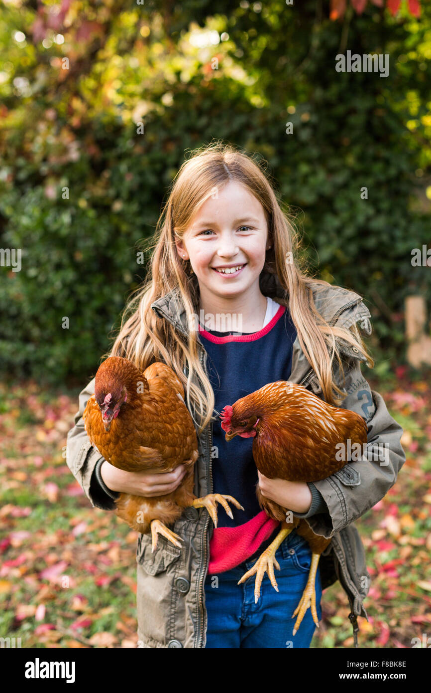 Petite fille de 9 ans avec des poules. Banque D'Images