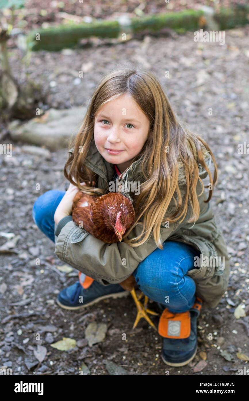 Petite fille de 9 ans avec des poules. Banque D'Images