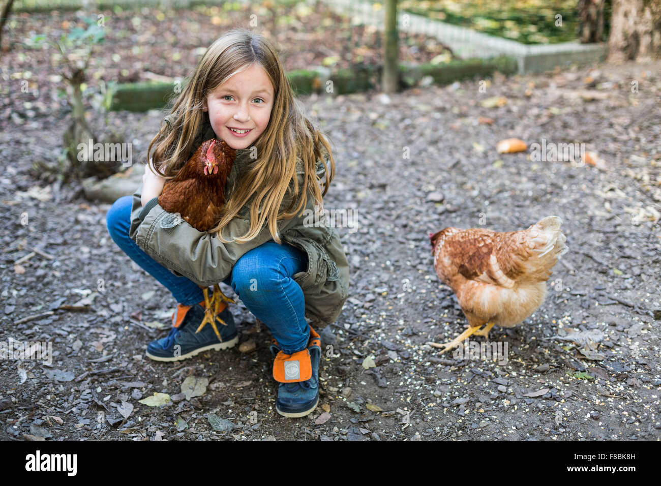 Petite fille de 9 ans avec des poules. Banque D'Images