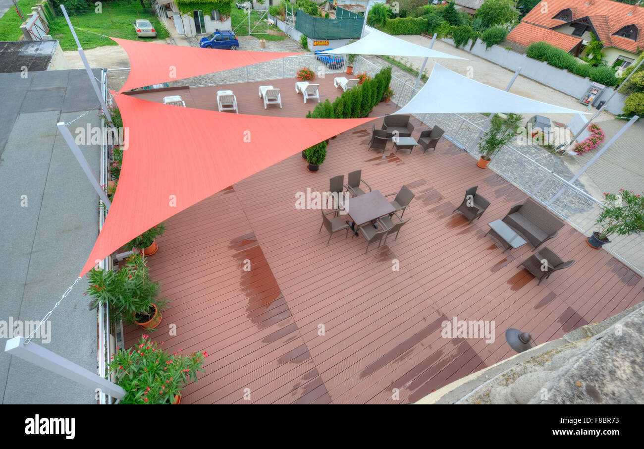 Terrasse en été avec des voiles d'ombre, des fleurs et des chaises longues Banque D'Images