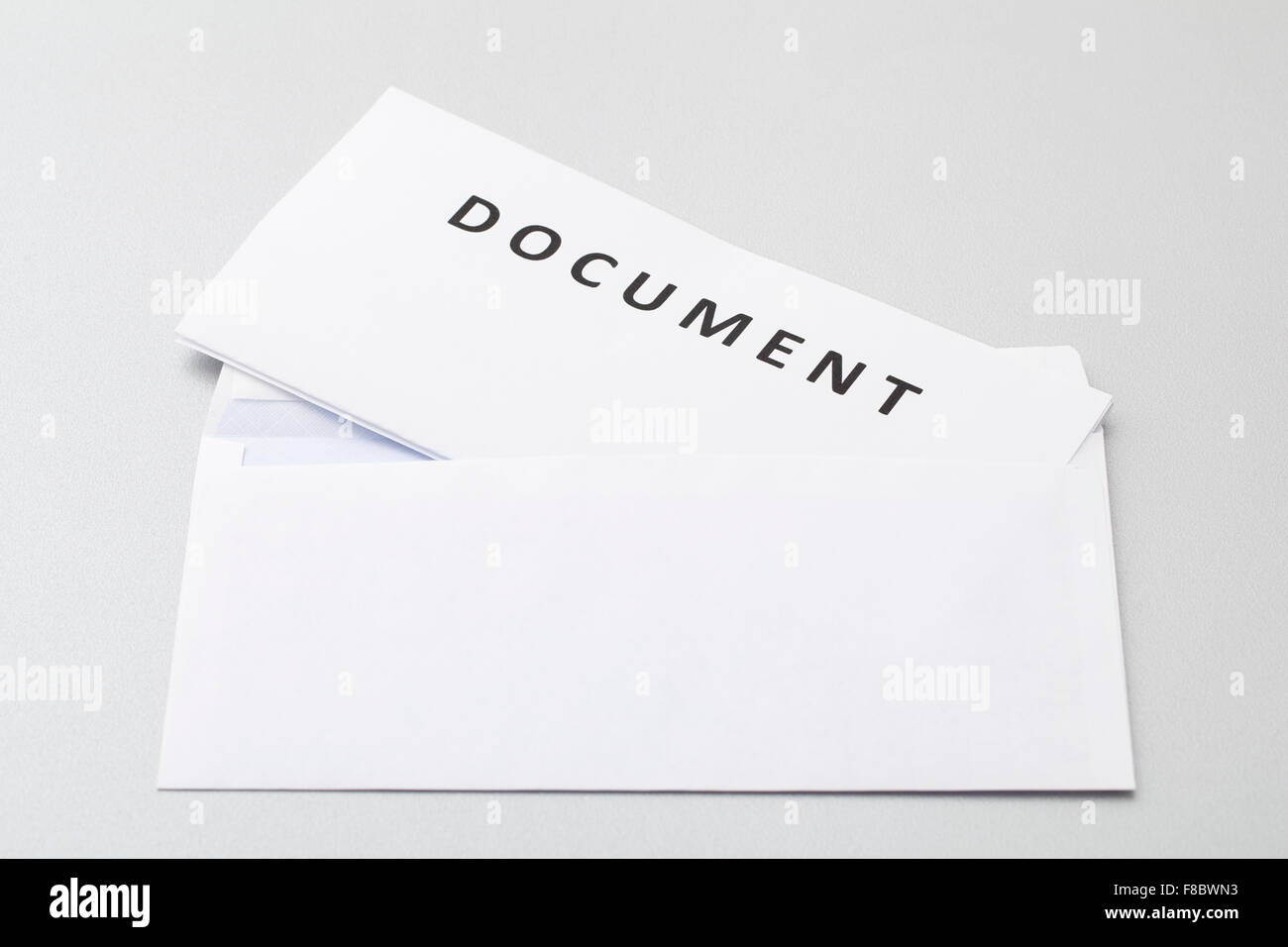 Document plié draps blancs mis en enveloppe blanche vierge, isolé sur l'arrière-plan. Banque D'Images