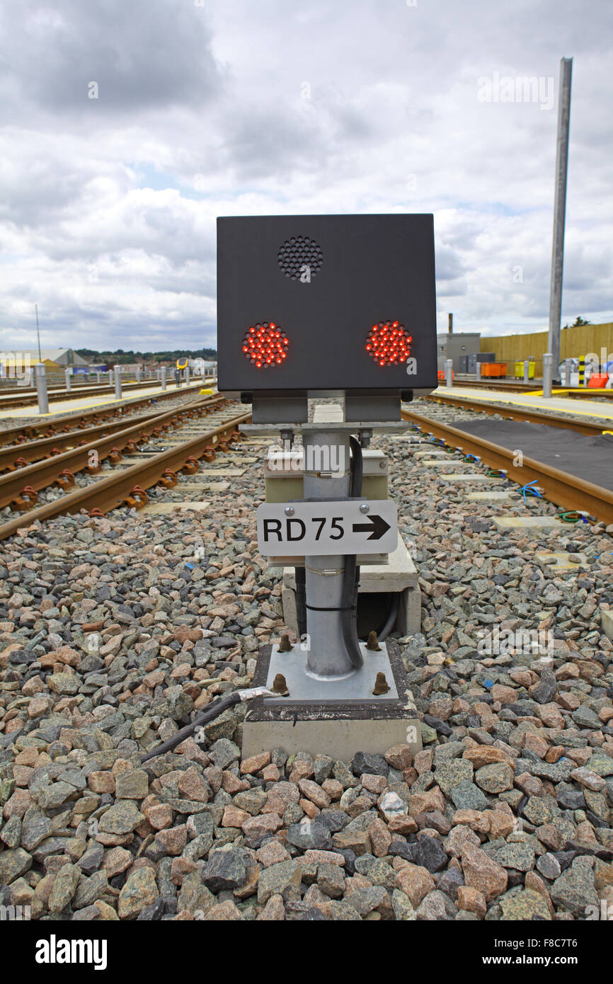 Le signal de position au sol nombre RD 75 montrant deux LED rouge s'allume de la boîte noire se tenait sur un pilier vissé sur une base en béton. Banque D'Images