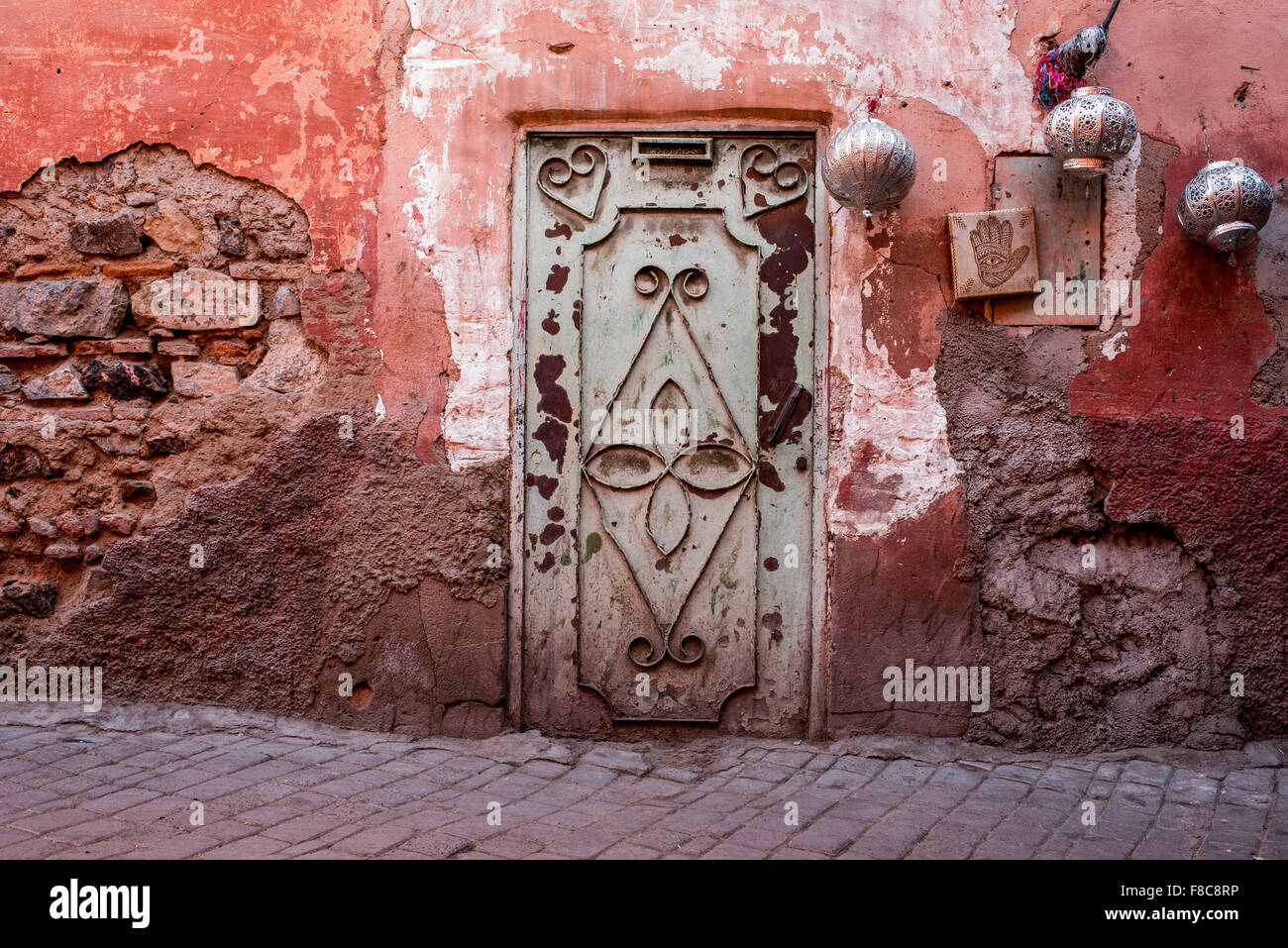 Porte Verte dans un mur avec des lanternes rouges d'argent dans une rue à proximité du souk de Marrakech, Maroc. Banque D'Images