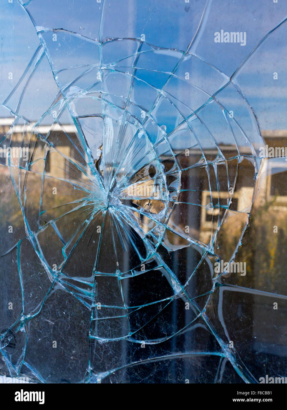 Vue en gros de verre cassé sur une fenêtre avec des fissures rayonnant à partir du centre Banque D'Images