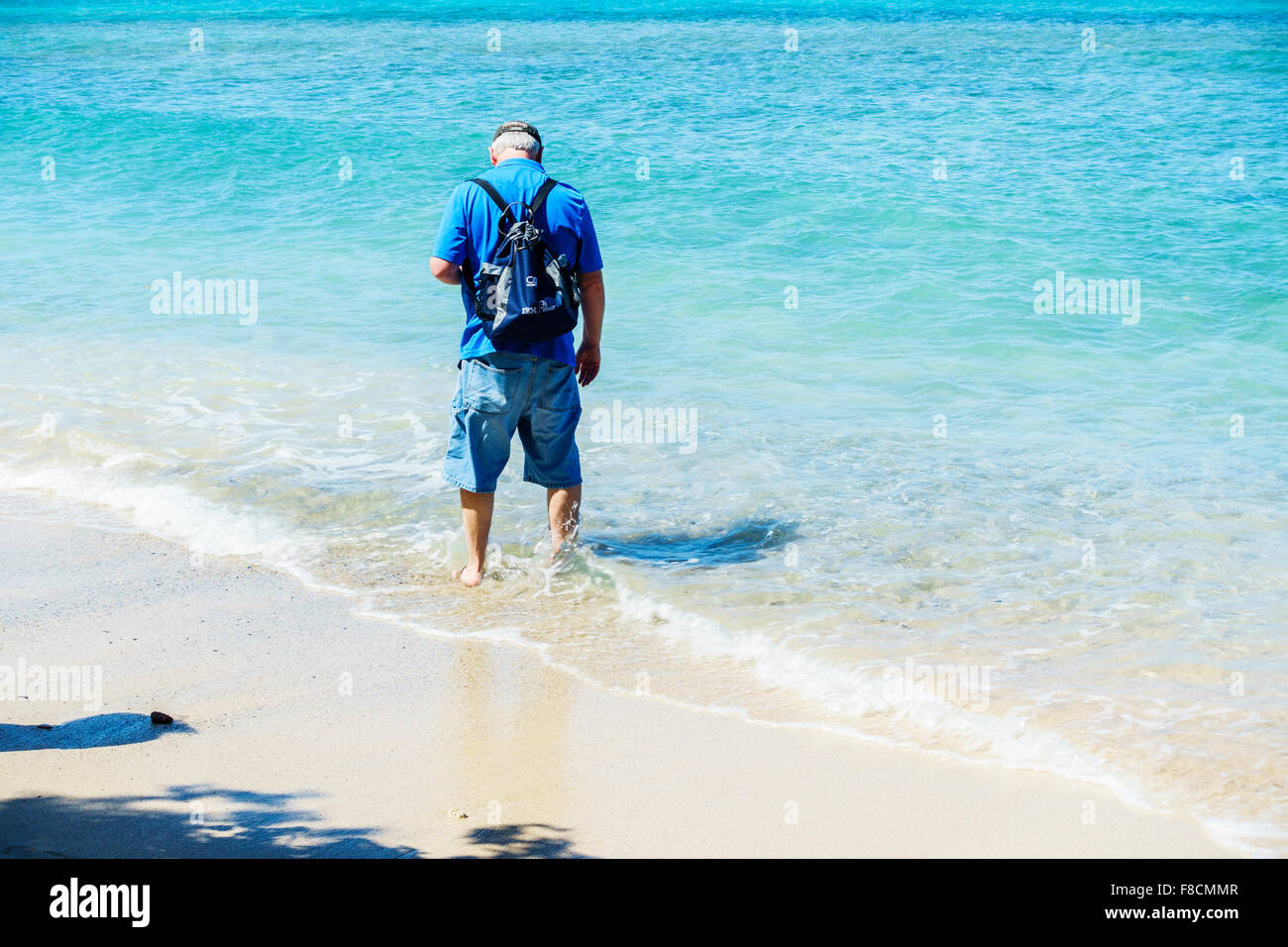 Un 50 ans caucasien homme patauge dans les eaux peu profondes de la Caraïbes, à Sainte-Croix, les Îles Vierges des États-Unis, côte-nord. Banque D'Images