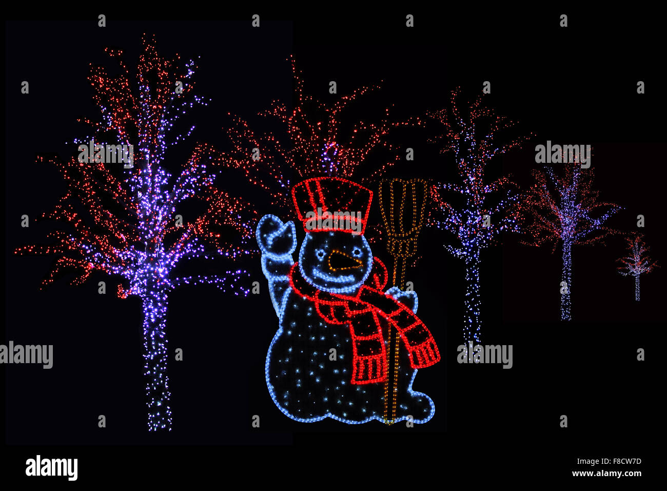 Photo de nuit en plein air d'arbres illuminés et bonhomme de neige pour l'atmosphère de Noël parfait Banque D'Images