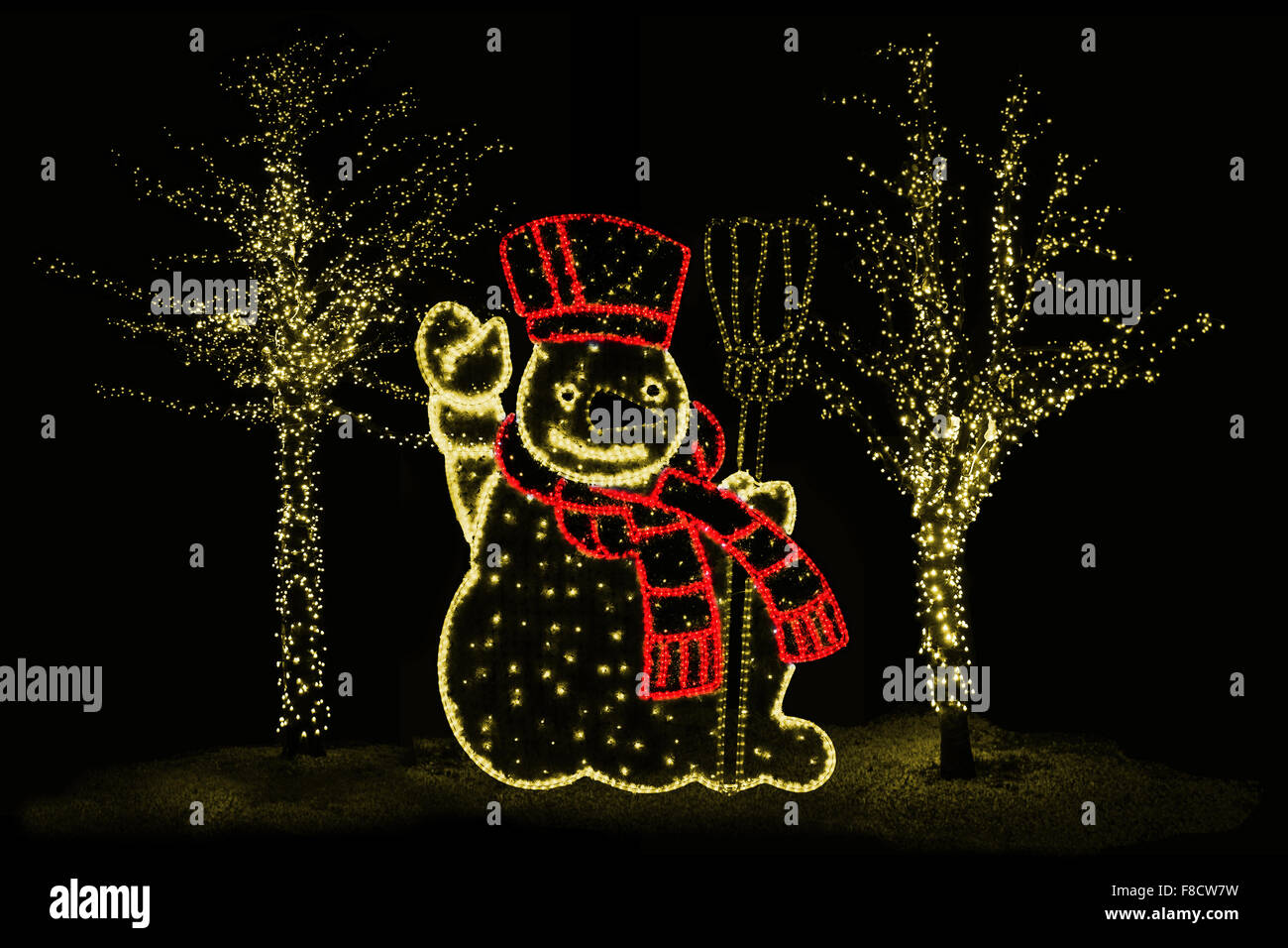 Photo de nuit en plein air d'arbres illuminés et bonhomme de neige pour l'atmosphère de Noël parfait Banque D'Images