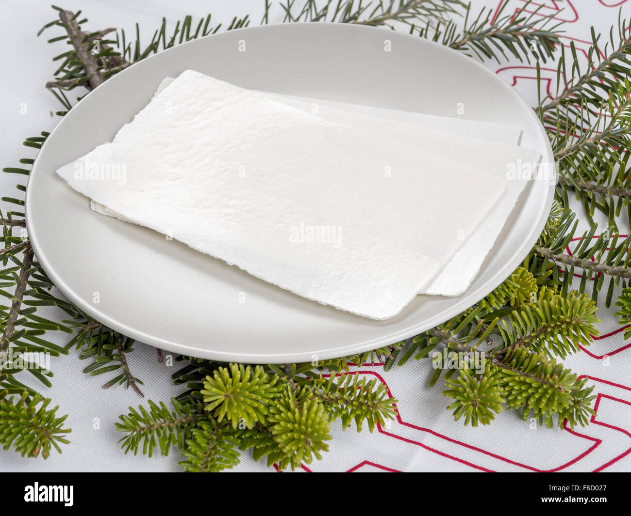 La veille de Noël traditionnelle galette blanche sur une plaque avec des pousses du sapin Banque D'Images