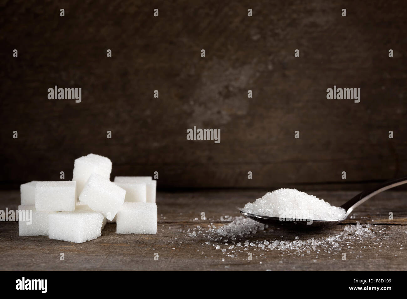 Sucre blanc en cuillère en argent sur table en bois Banque D'Images