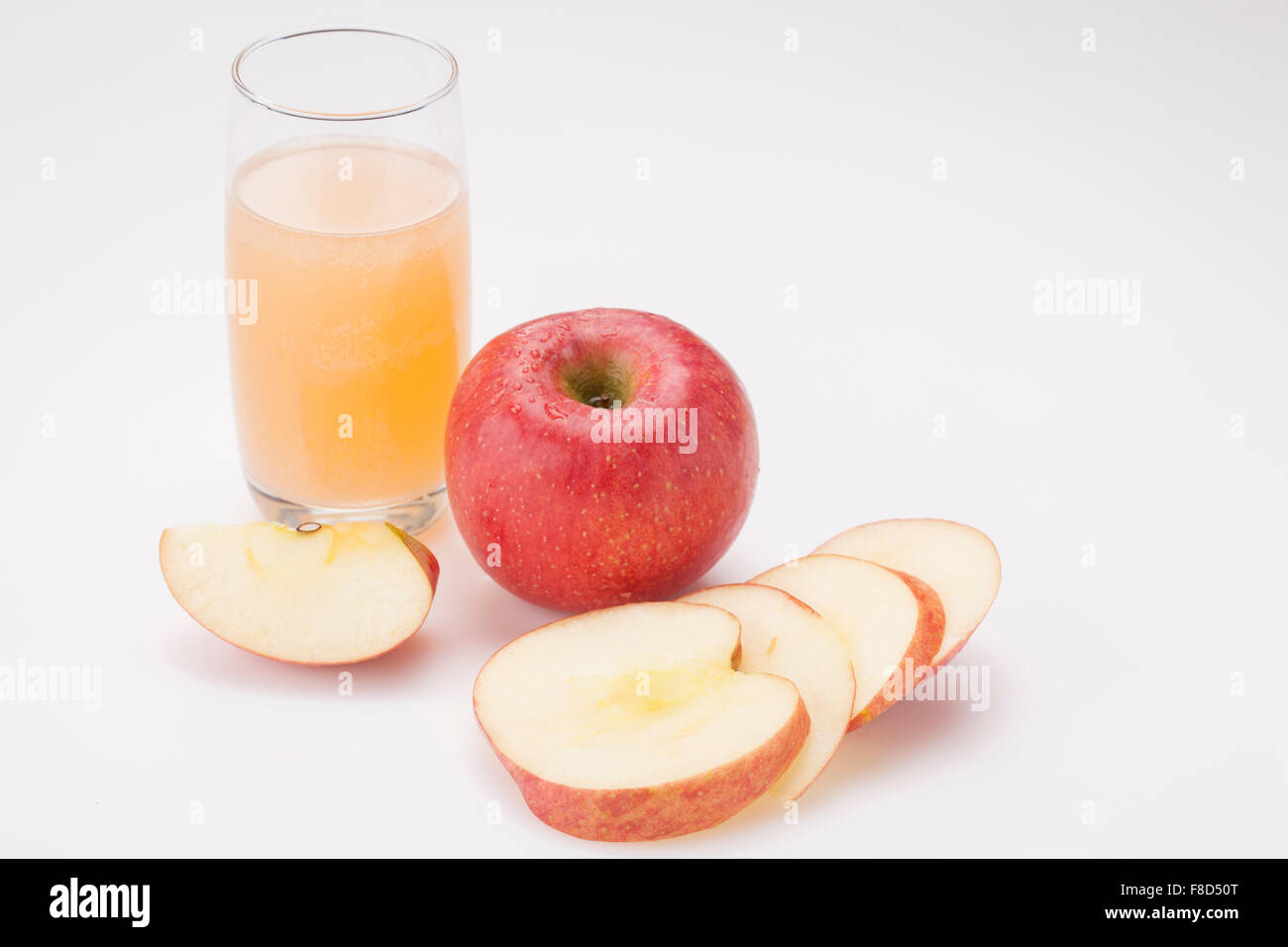 Verre de jus de pomme et une pomme entière et des tranches de pomme Banque D'Images