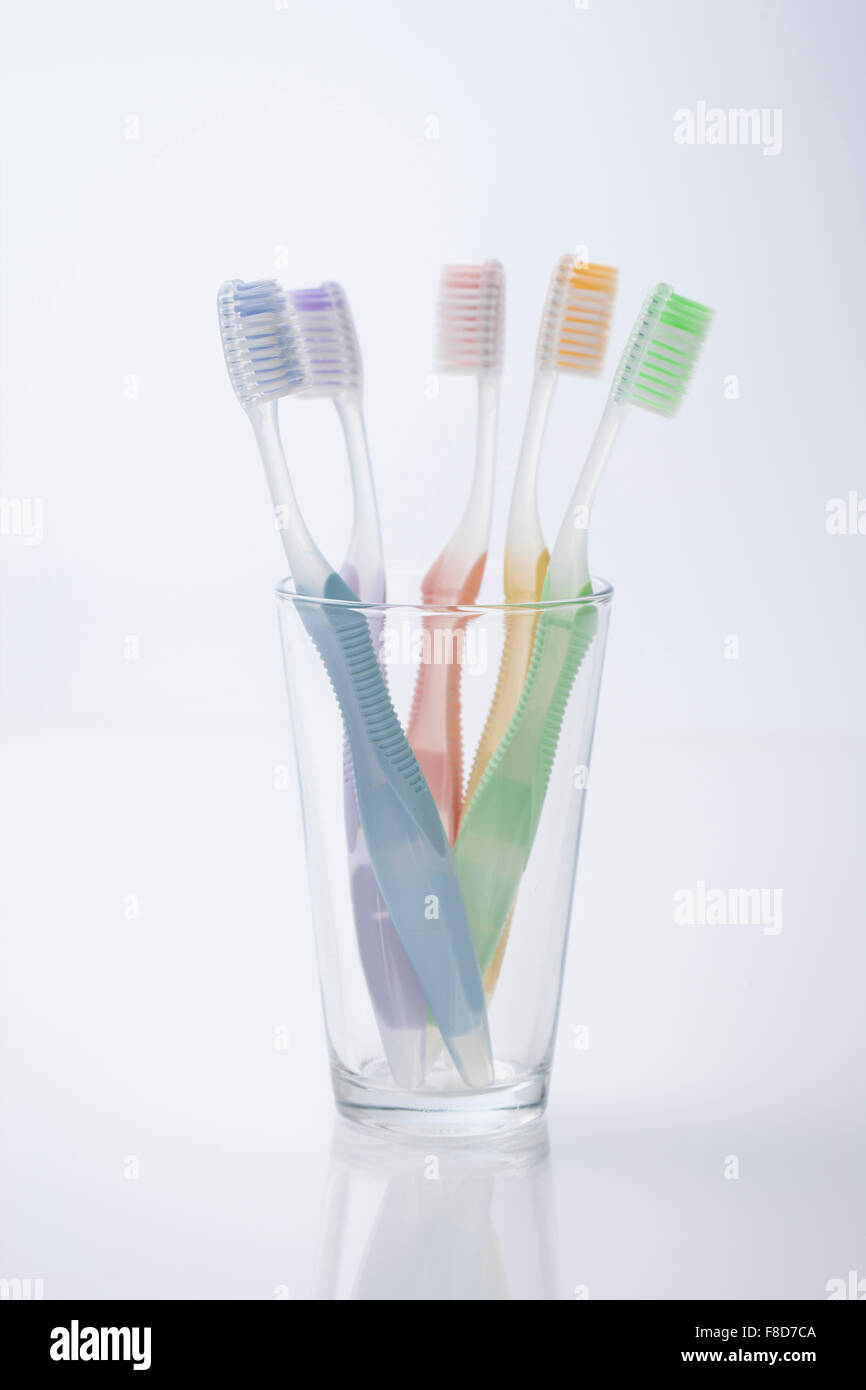 Cinq différentes couleurs de brosses à dents dans une tasse Banque D'Images