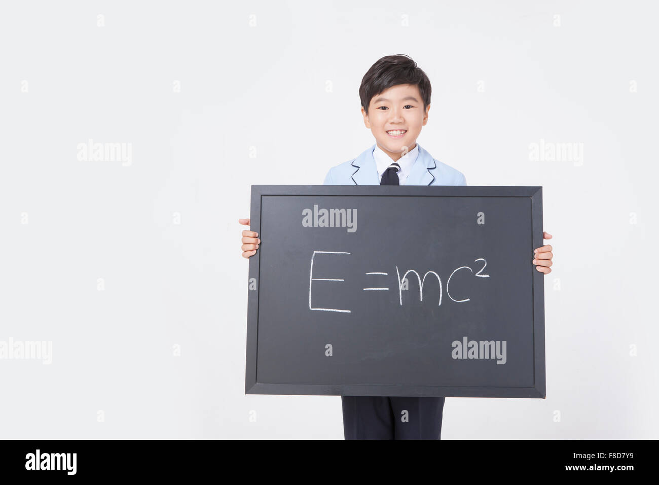 L'âge de l'école élémentaire boy holding un tableau noir avec écrit dessus formule scientifique Banque D'Images