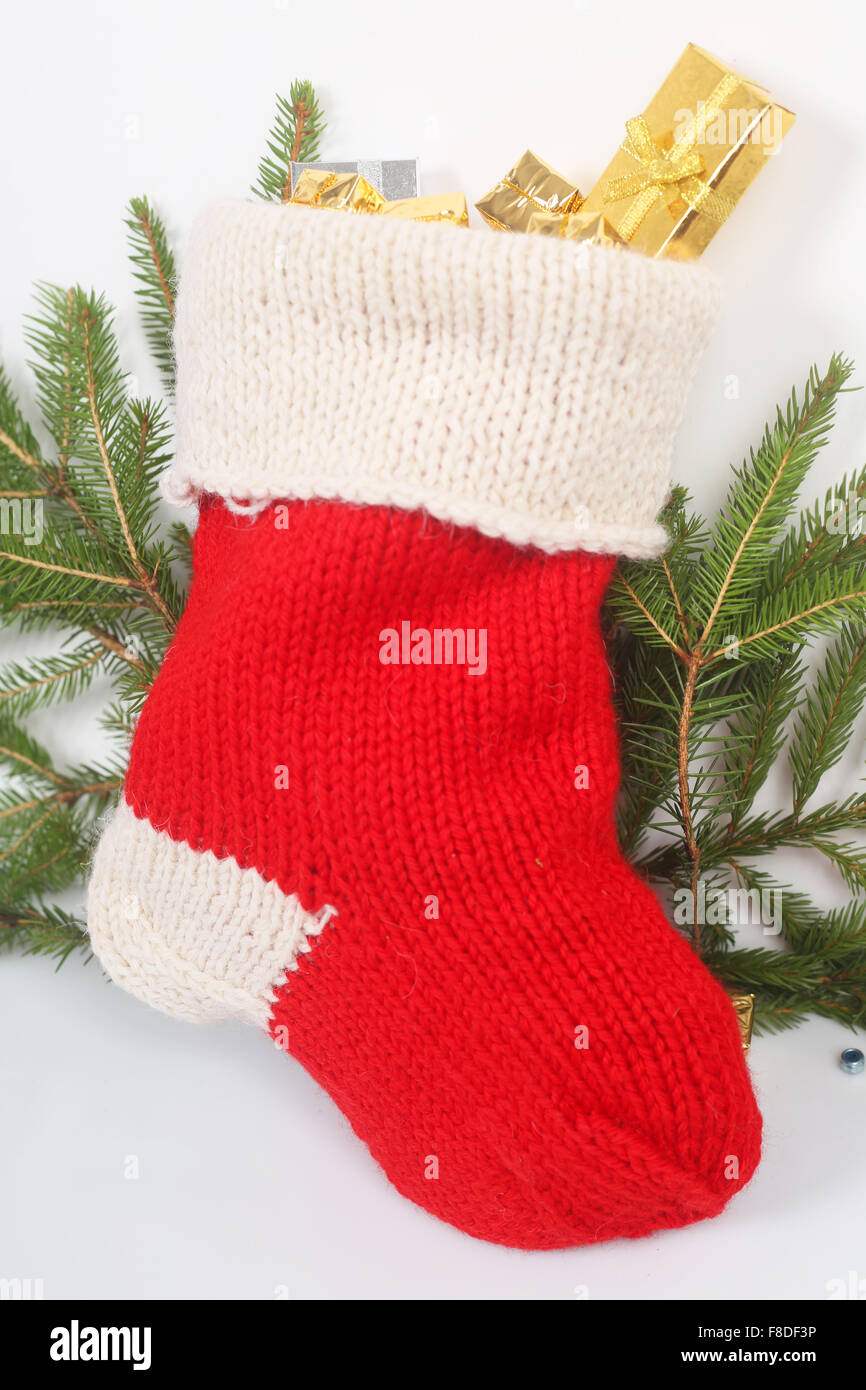 Chaussette de Noël rouge avec des cadeaux sur fond blanc Banque D'Images