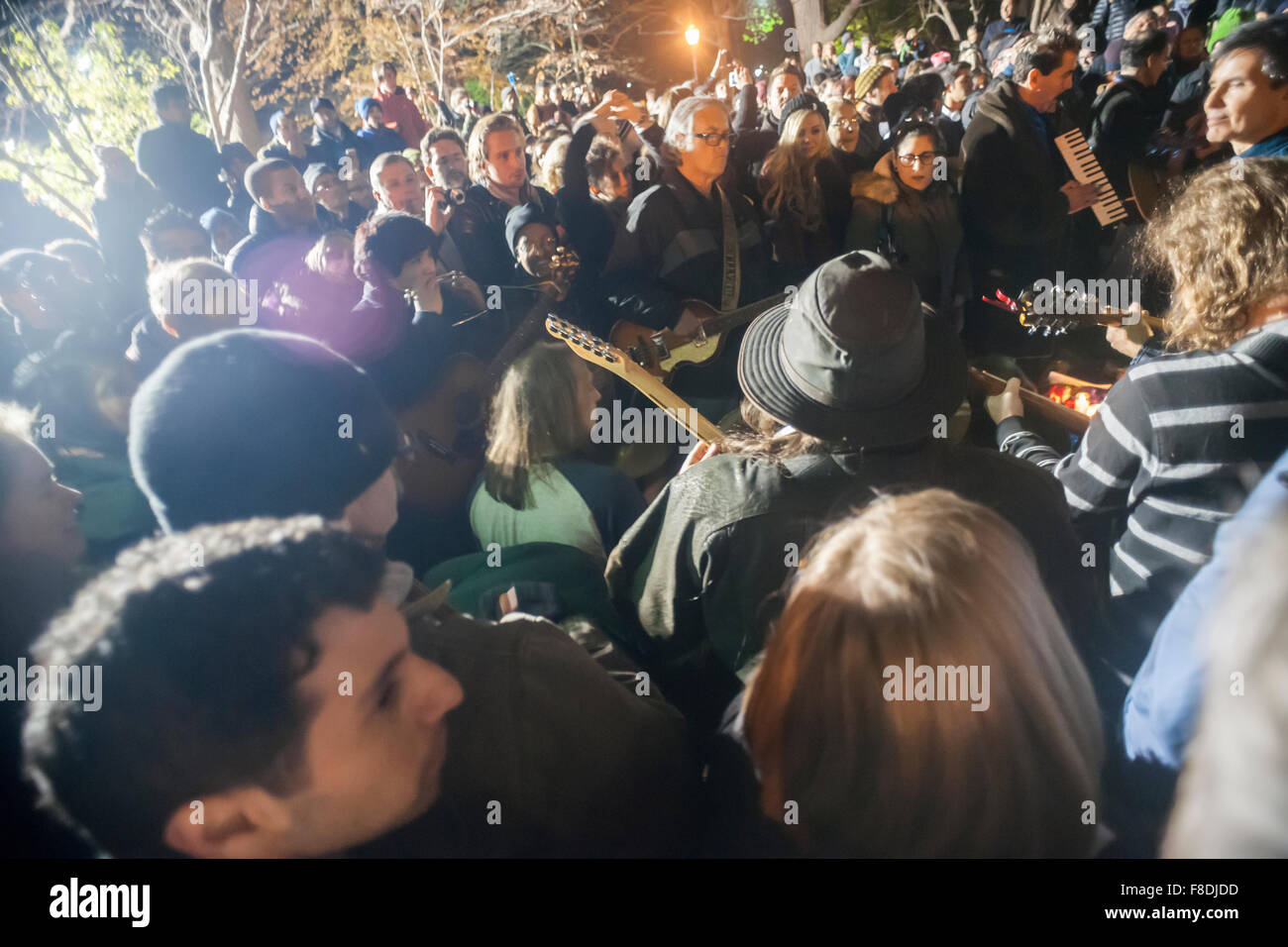 New York, New York, USA. Le 08 déc, 2015. Des centaines de fans de la fin des Beatles, John Lennon se rassemblent dans les champs de fraises de Central Park le Mardi, Décembre 8, 2015 pour commémorer le 35e anniversaire de la mort de Lennon. Lennon a été abattu devant son domicile dans le Dakota Apartments par tireur fou Mark David Chapman. Les fans comprenaient des gens qui se souvenaient de l'endroit où ils étaient sur cette nuit et de nombreuses personnes plus jeunes qui ne sont pas assez vieux pour se souvenir de Lennon, un hommage durable à sa musique. Crédit : Richard Levine/Alamy Live News Banque D'Images