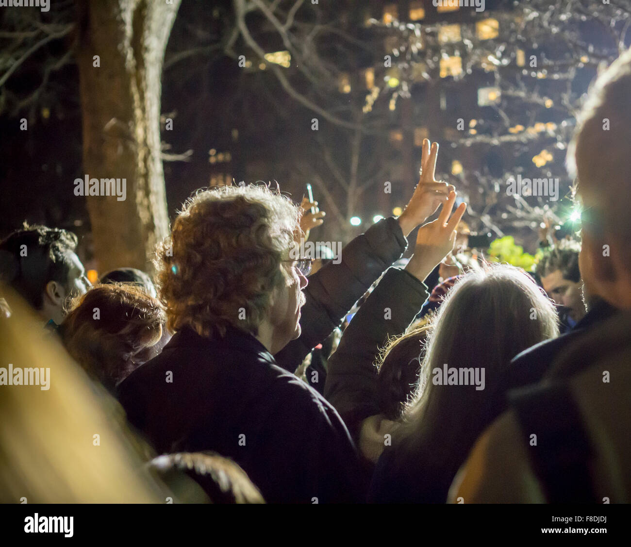 New York, New York, USA. Le 08 déc, 2015. Des centaines de fans de la fin des Beatles, John Lennon se rassemblent dans les champs de fraises de Central Park le Mardi, Décembre 8, 2015 pour commémorer le 35e anniversaire de la mort de Lennon. Lennon a été abattu devant son domicile dans le Dakota Apartments par tireur fou Mark David Chapman. Les fans comprenaient des gens qui se souvenaient de l'endroit où ils étaient sur cette nuit et de nombreuses personnes plus jeunes qui ne sont pas assez vieux pour se souvenir de Lennon, un hommage durable à sa musique. Crédit : Richard Levine/Alamy Live News Banque D'Images