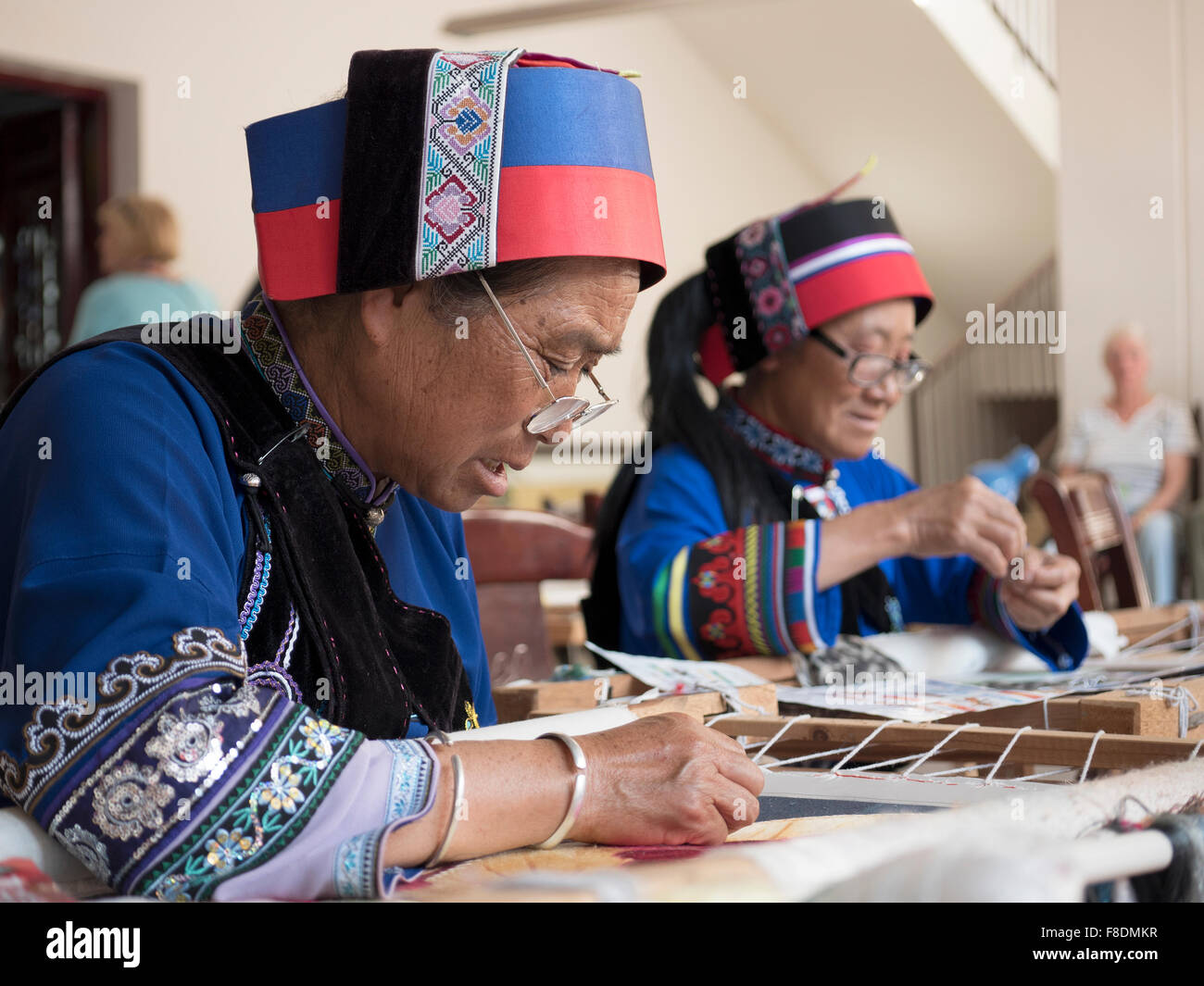 Personnes âgées Personnes ethnique Yi femmes portant le costume traditionnel tapisserie Couture Dessins Dans Suogeyi Village, Yunnan, Chine Banque D'Images