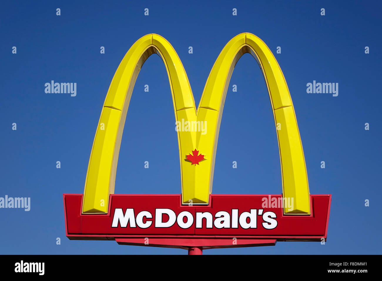 Les Arches d'or canadiennes sont le signe de la chaîne de restaurants McDonald's Hamburger Sur fond ciel bleu Banque D'Images