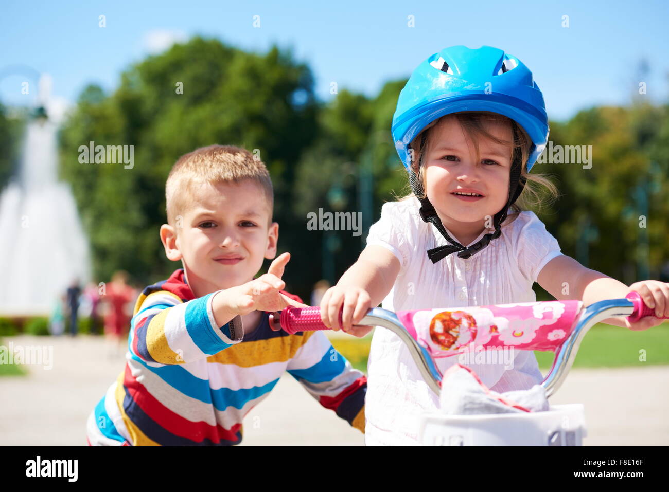 Piscine pour enfants heureux, frère et soeur dans le parc s'amuser. Garçon et fille dans l'apprentissage du parc à vélo. Banque D'Images