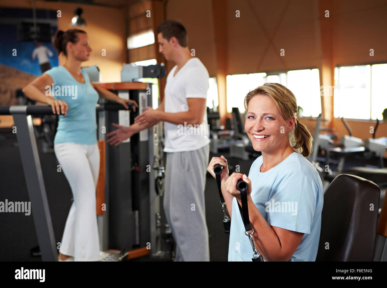 Les femmes qui font des exercices de remise en forme dans une salle de sport avec un entraîneur de forme physique Banque D'Images