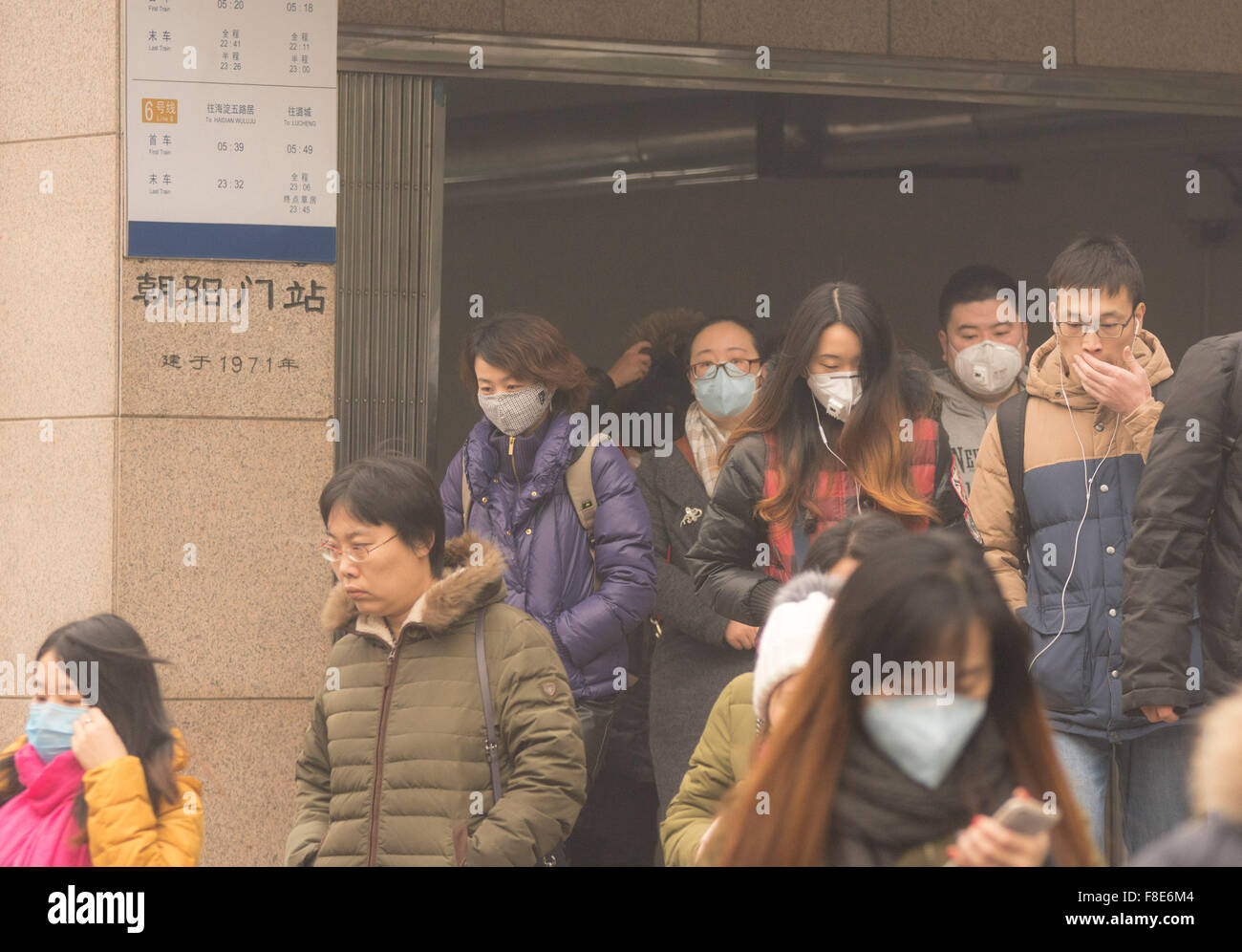 Les gens et les navetteurs portent un masque facial sur leur chemin vers le travail, bravant ainsi la lourde pollution de l'air dans la capitale chinoise alors que les niveaux ont grimpé à plus de 20 fois les niveaux de sécurité, ce qui a donné lieu à une alerte rouge pour tout Pékin. © Olli Geibel Banque D'Images