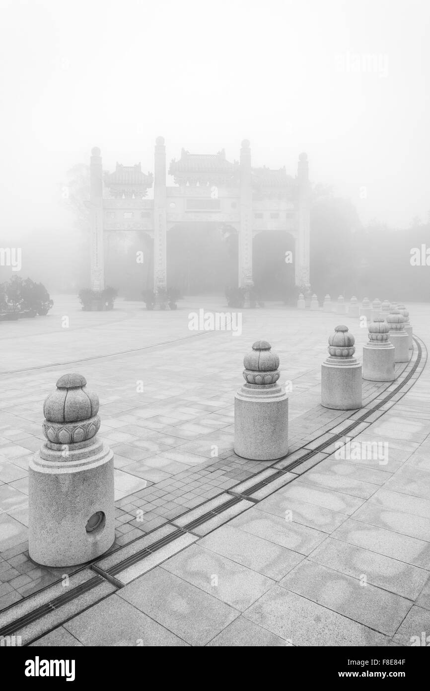 Mountain Gate au monastère Po Lin sur l'île de Lantau à Hong Kong, Chine, lors d'un matin brumeux en noir&blanc. Banque D'Images