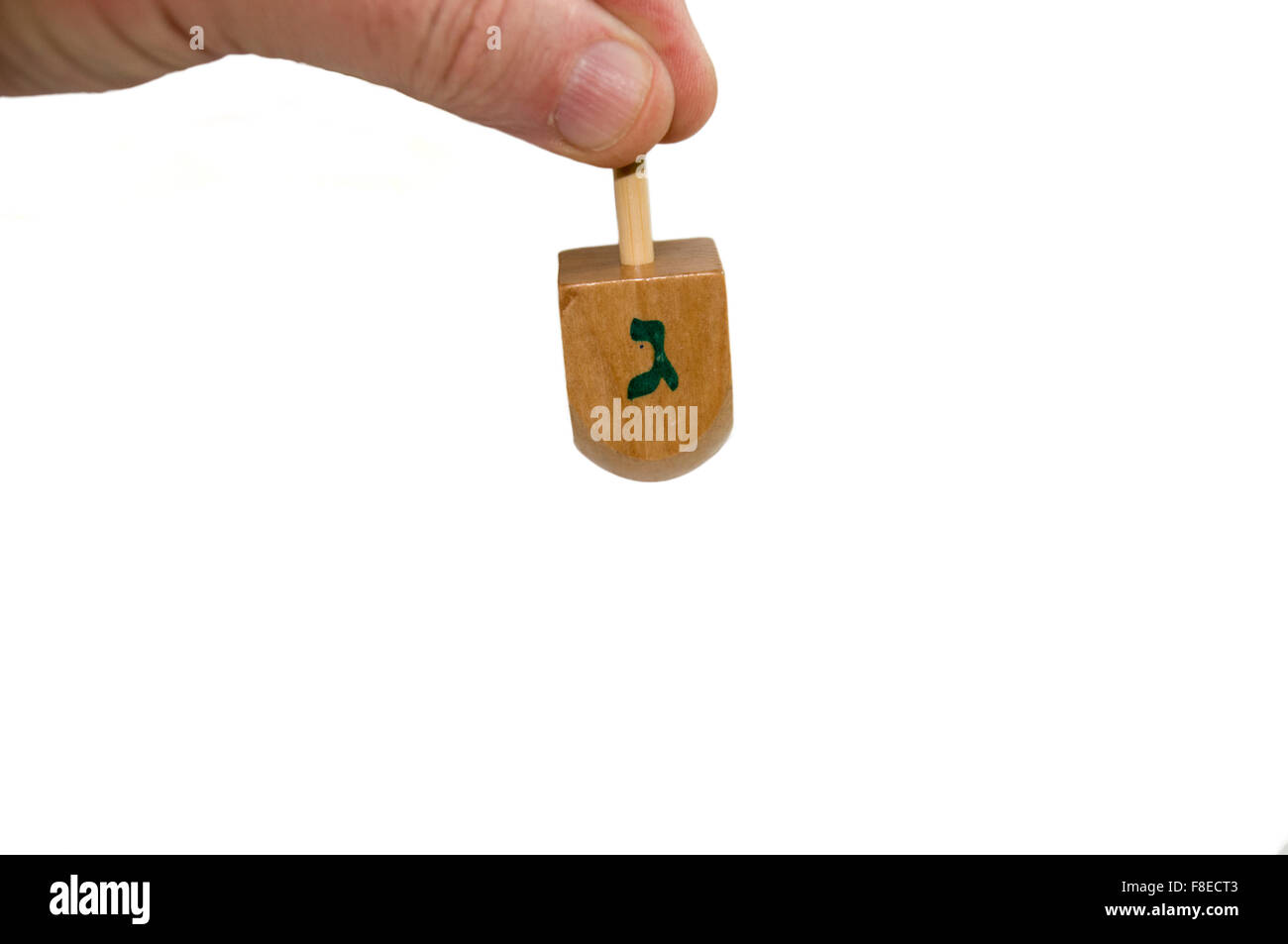 La main de l'homme la rotation d'un Sevivon ou Dreidel une toupie  traditionnellement joué pendant 'Hanoucca Photo Stock - Alamy