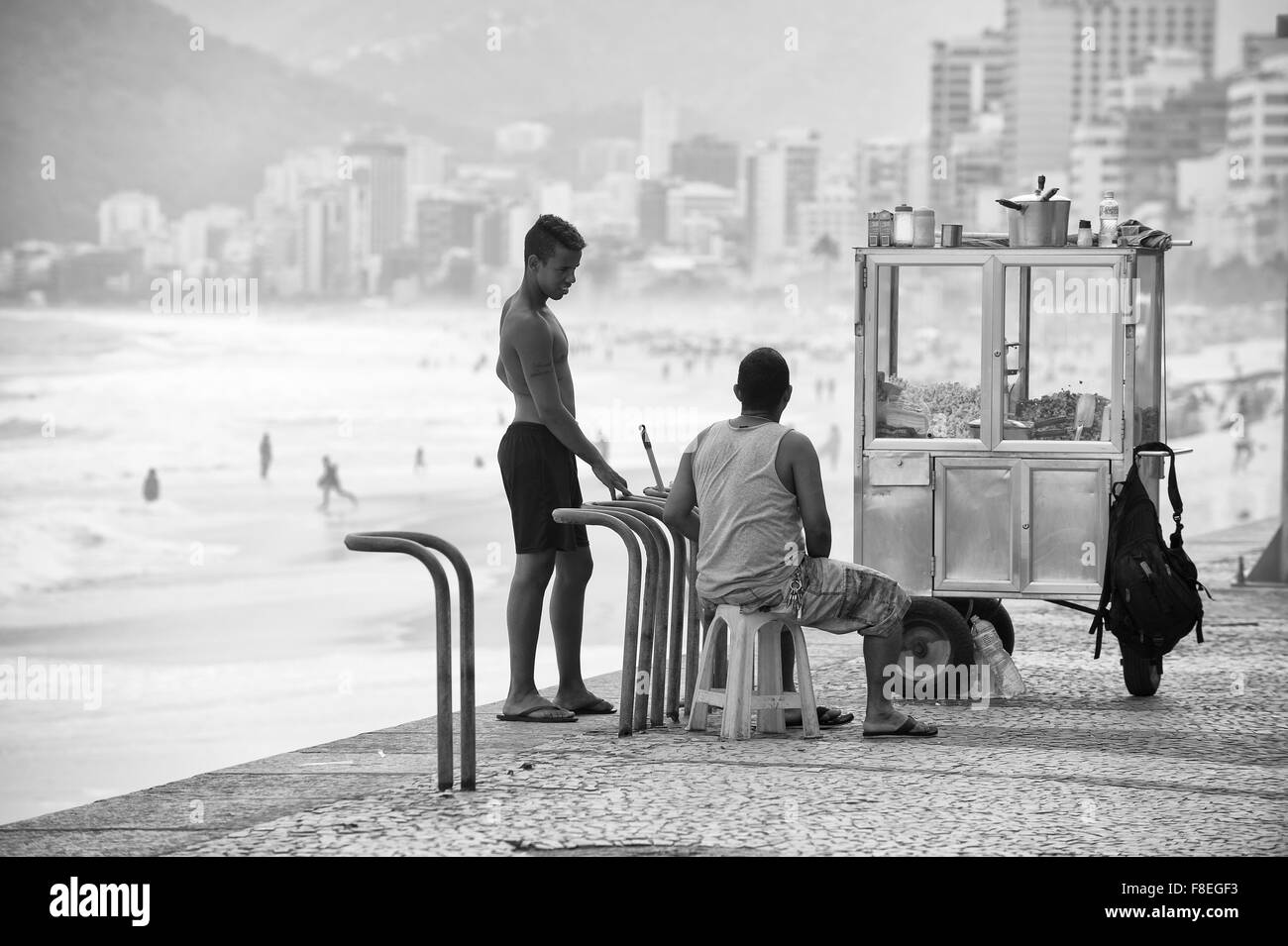 RIO DE JANEIRO, Brésil - 22 octobre 2015 : Vendor selling popcorn attend avec son chariot mobile à l'Arpoador donnent sur. Banque D'Images