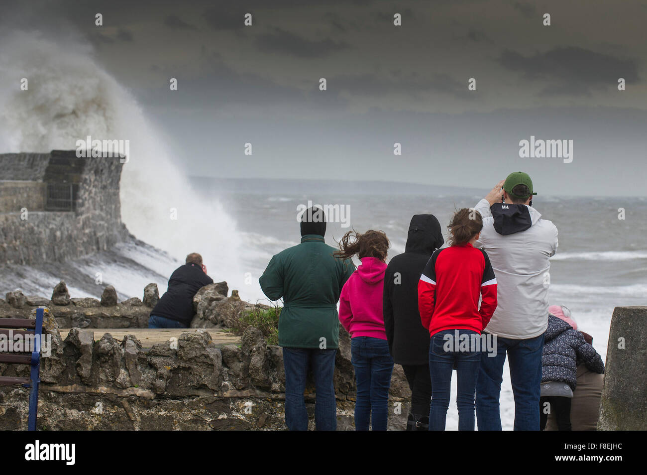 Les gens regardent comme d'énormes vagues s'écraser sur le quai sur le front de mer de Porthcawl, dans le sud du Pays de Galles. Banque D'Images