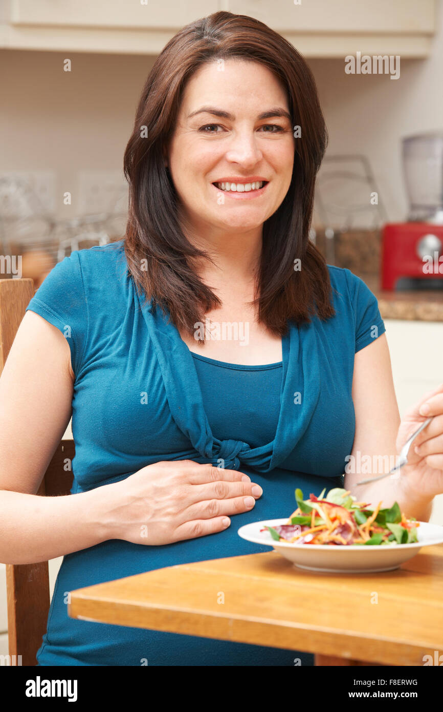 Pregnant Woman Eating Salade saine à la maison Banque D'Images