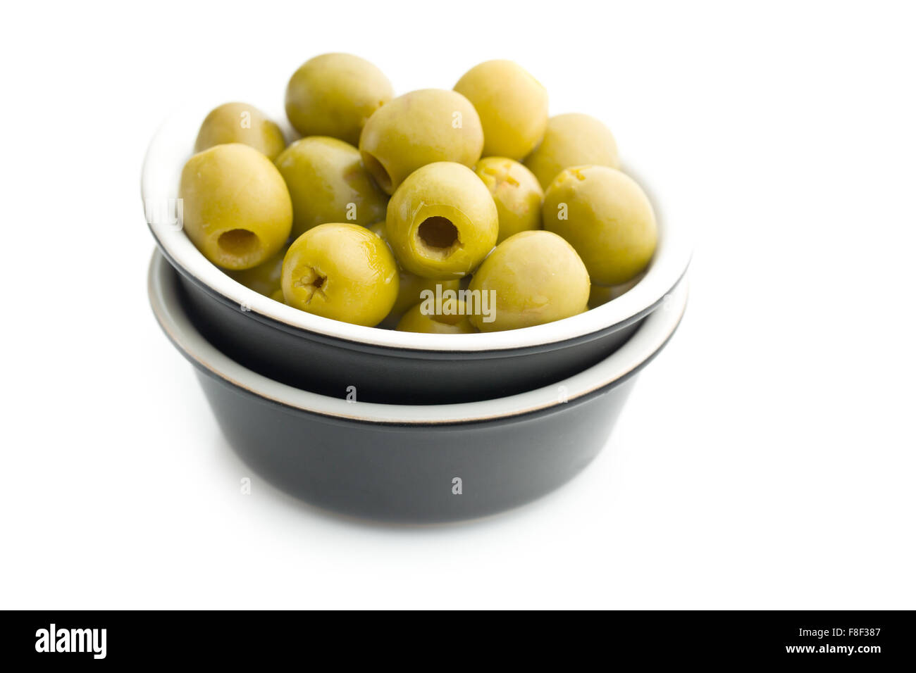 Olives vertes dénoyautées dans un bol sur fond blanc Banque D'Images