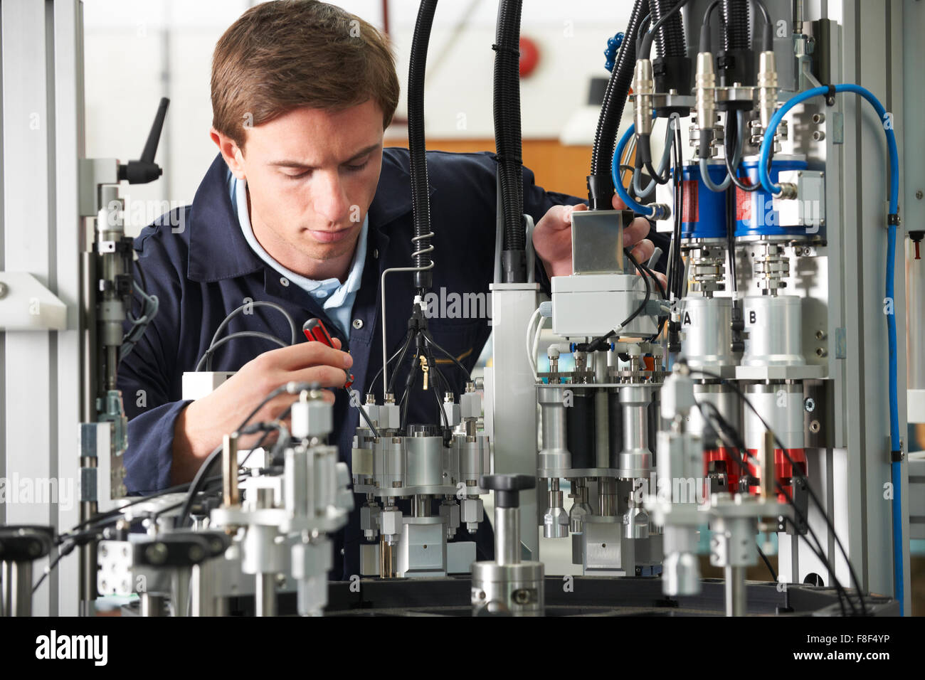 Ingénieur travaillant sur un équipement complexe en usine Banque D'Images
