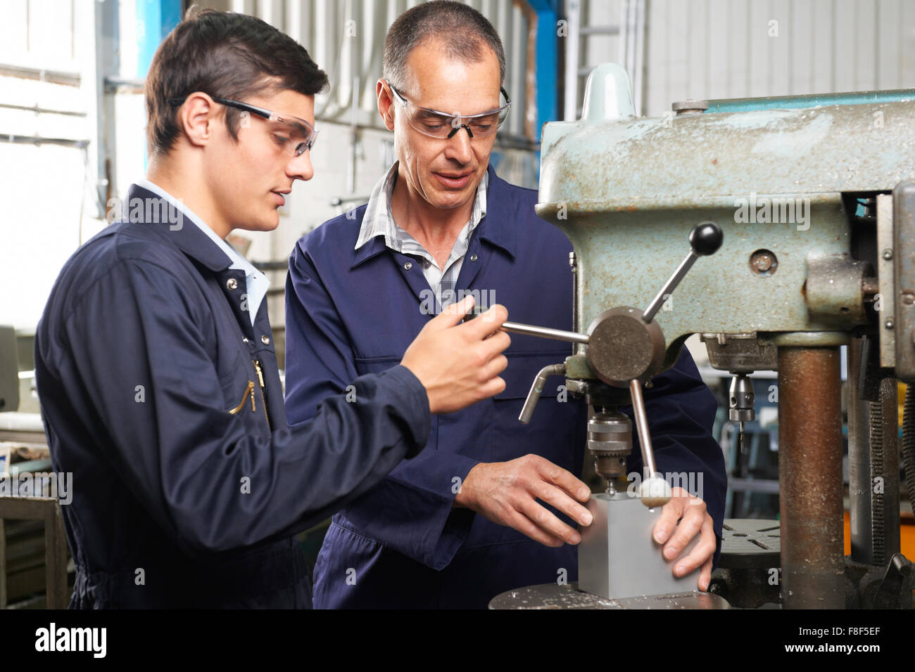 Apprenti ingénieur travaillant avec l'aide de percer Banque D'Images