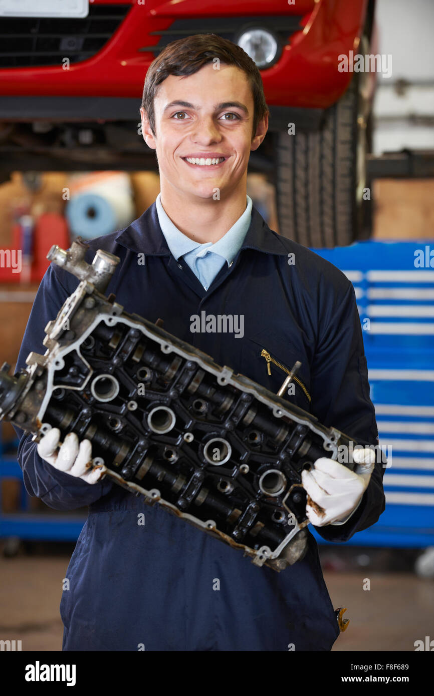 Apprenti Machanic Holding le bloc-moteur dans le garage Banque D'Images